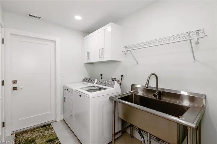 Laundry area with washer and dryer, cabinet space, and recessed lighting