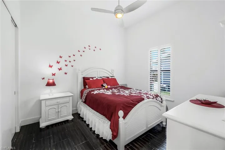 Bedroom featuring a ceiling fan, dark wood-type flooring, and a closet