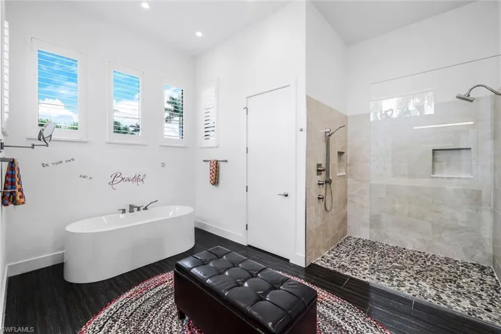 Full bathroom featuring a walk in shower, a freestanding bath, wood finished floors, and recessed lighting