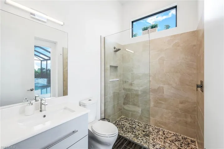 Bathroom featuring a walk in shower and vanity