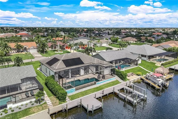 Aerial perspective of suburban area with a large body of water and a pool