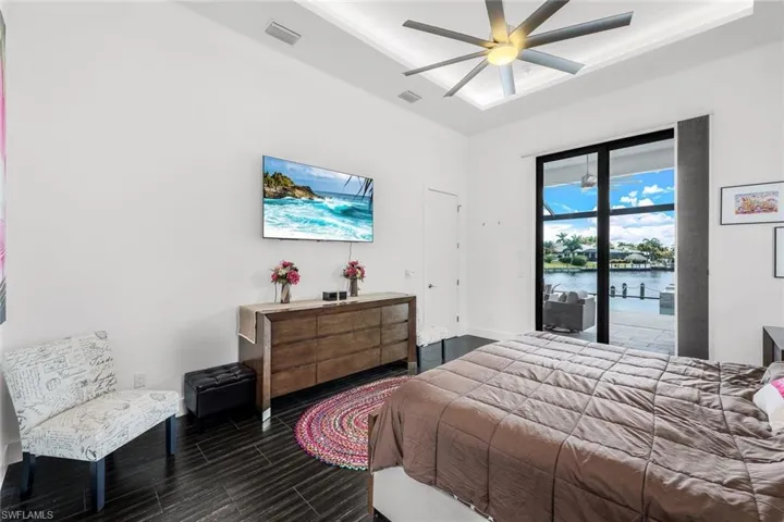 Bedroom with access to exterior, a ceiling fan, and wood finished floors