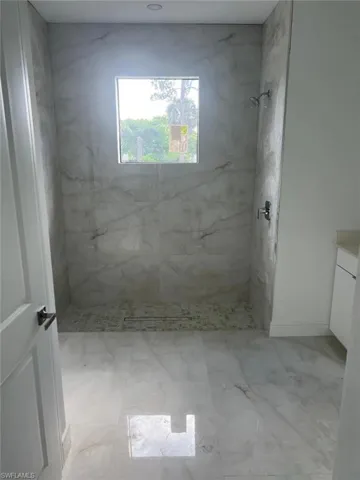 Master Shower flooring, a tile shower, and vanity