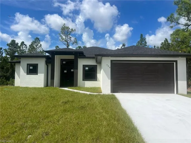 Prairie-style house featuring a front lawn and a garage