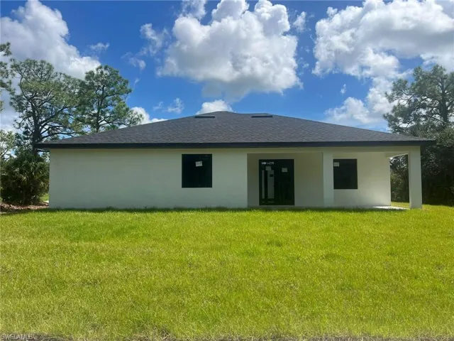Back of house with a yard