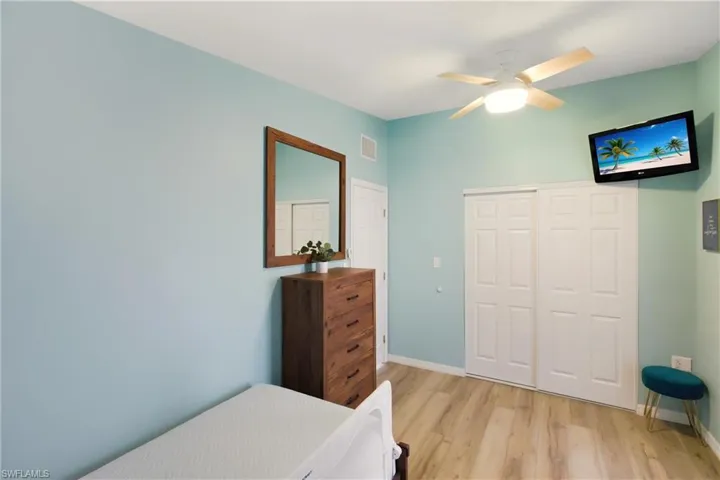Bedroom with a closet, light wood-type flooring, and ceiling fan
