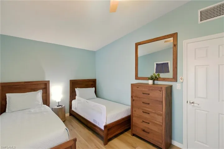 Bedroom featuring vaulted ceiling, wood finished floors, and ceiling fan