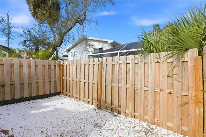 Fenced backyard featuring a lanai