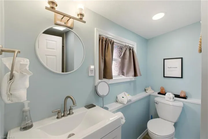 Half bathroom featuring vanity and toilet