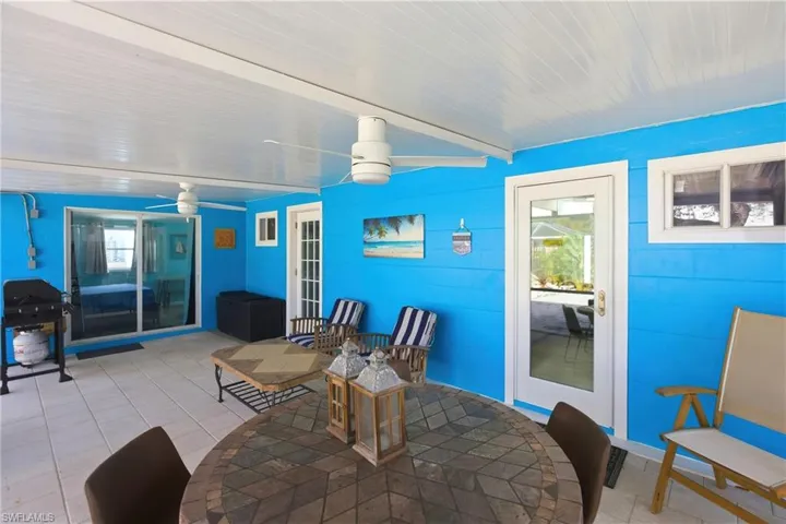 Tiled dining room featuring beam ceiling and a ceiling fan