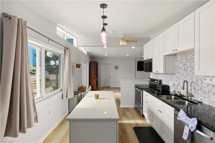 Kitchen featuring appliances with stainless steel finishes, white cabinets, tasteful backsplash, dark stone countertops, and recessed lighting