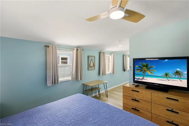 Bedroom with ceiling fan and light wood-style floors
