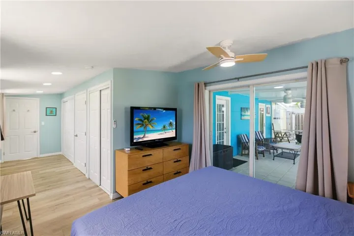 Bedroom with access to exterior, light wood finished floors, multiple closets, a ceiling fan, and recessed lighting