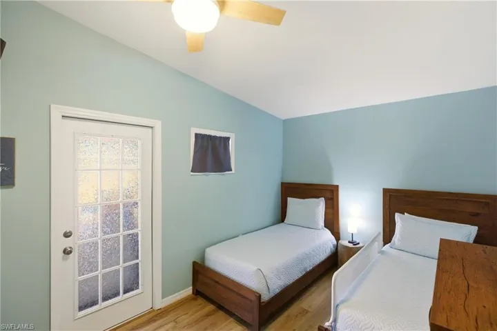 Bedroom with wood finished floors, lofted ceiling, and ceiling fan