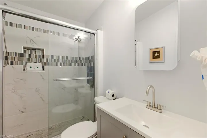 Full bath featuring vanity and a shower stall