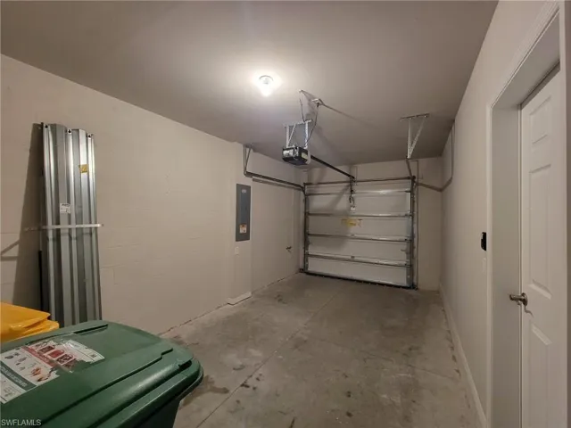 Garage with electric panel and a garage door opener