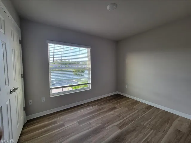 Empty room with a healthy amount of sunlight and hardwood / wood-style floors
