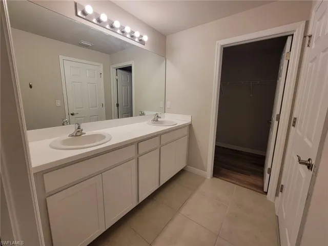 Bathroom with double sink vanity and tile patterned flooring
