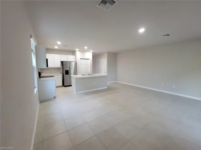 Unfurnished living room featuring sink and light tile patterned floors