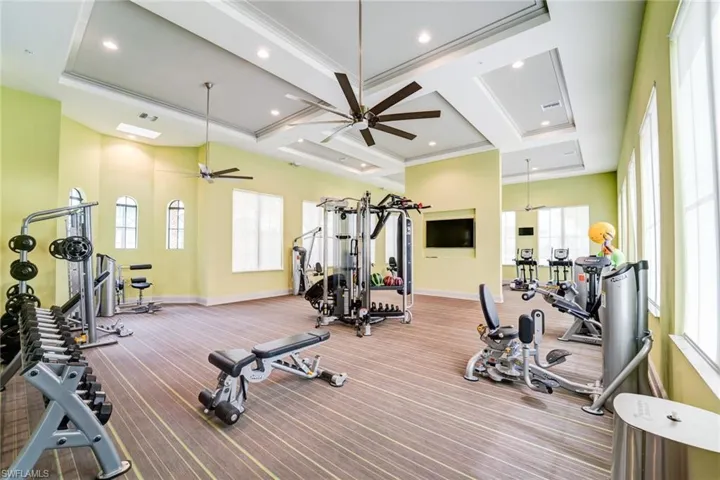 Gym featuring coffered ceiling, ceiling fan, and recessed lighting