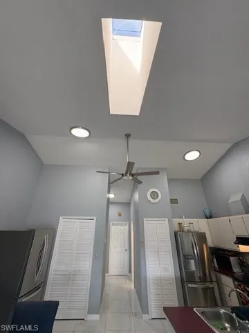 Kitchen featuring refrigerator, stainless steel refrigerator, a skylight, and recessed lighting