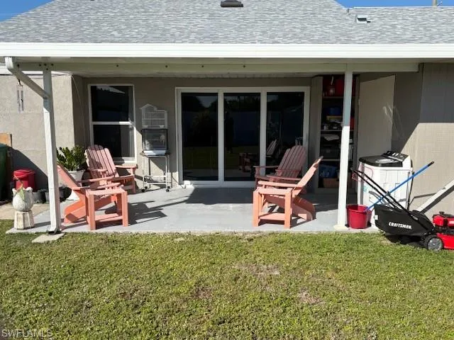 Rear view of house with roof with shingles, a patio area, and a yard