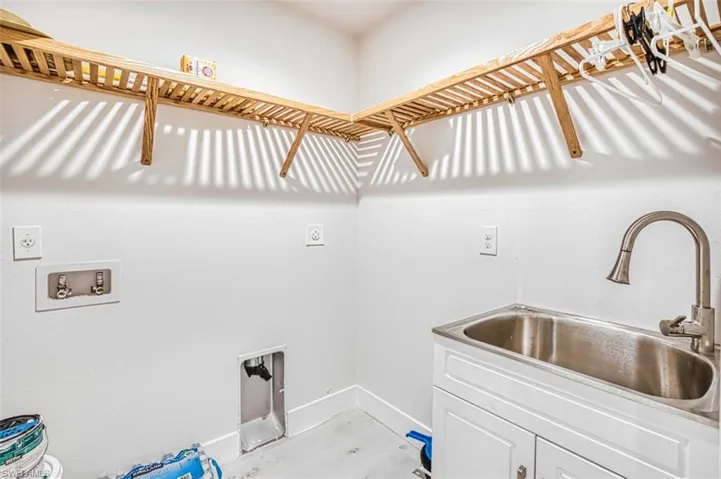 Laundry area featuring light wood finished floors, hookup for a washing machine, and hookup for an electric dryer