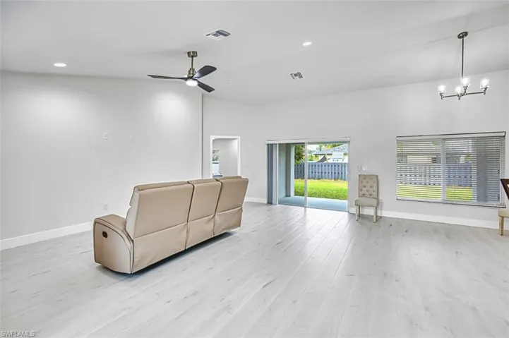 Unfurnished living room with recessed lighting, light wood-style flooring, a chandelier, and ceiling fan