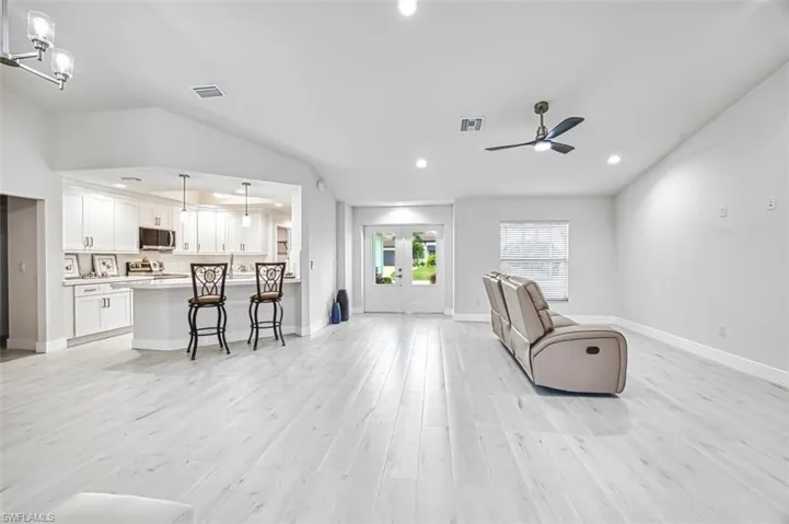 Living area with french doors, light wood-type flooring, ceiling fan, and recessed lighting
