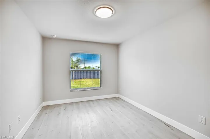 Unfurnished room with light wood finished floors and baseboards
