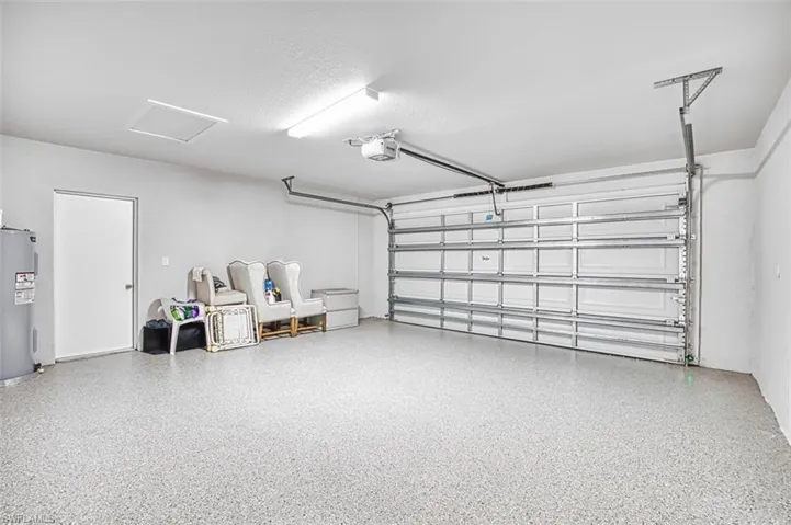 Garage featuring water heater and a garage door opener