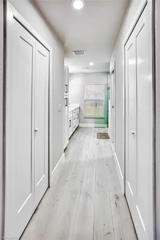 Hallway with recessed lighting and light wood-style flooring