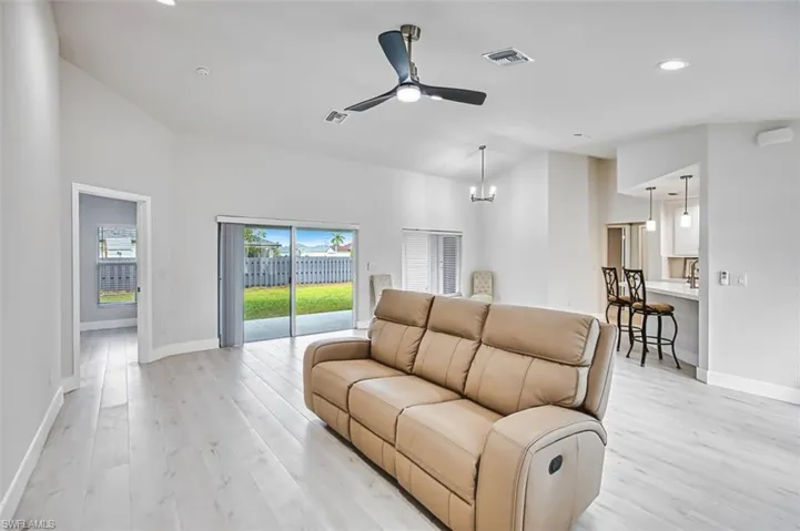 Living room featuring a ceiling fan, recessed lighting, light wood finished floors, and a chandelier