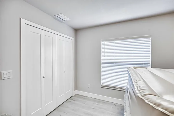 Bedroom with light wood-style flooring and a closet