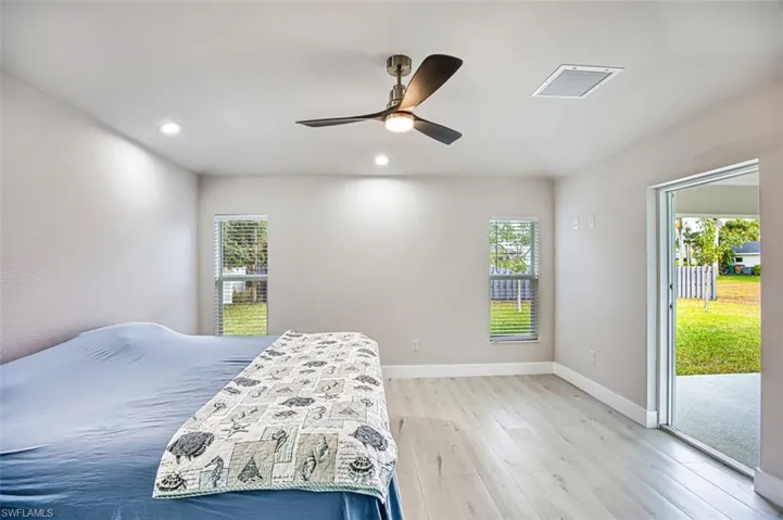 Bedroom with access to exterior, light wood finished floors, multiple windows, a ceiling fan, and recessed lighting