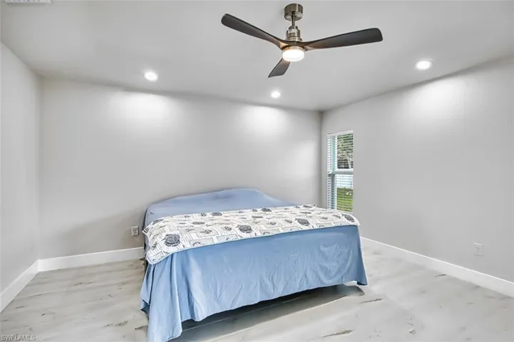 Bedroom featuring light wood finished floors, a ceiling fan, and recessed lighting