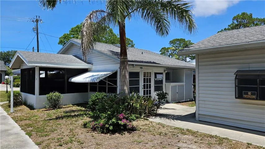 View of side of home featuring a sunroom and roof with shingles
