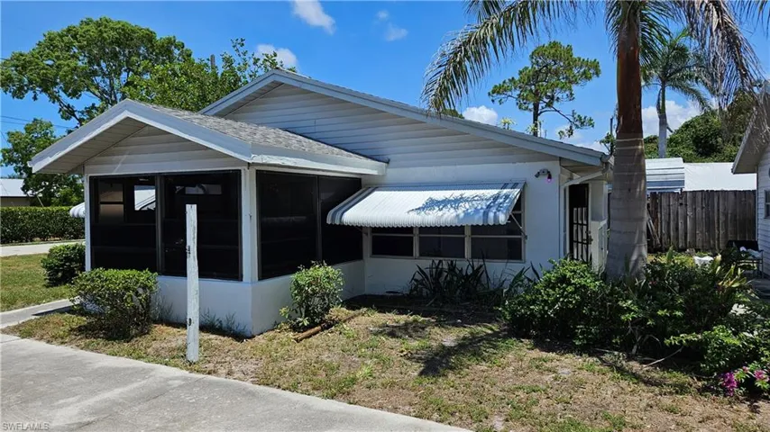 View of side of home with a sunroom and a shingled roof
