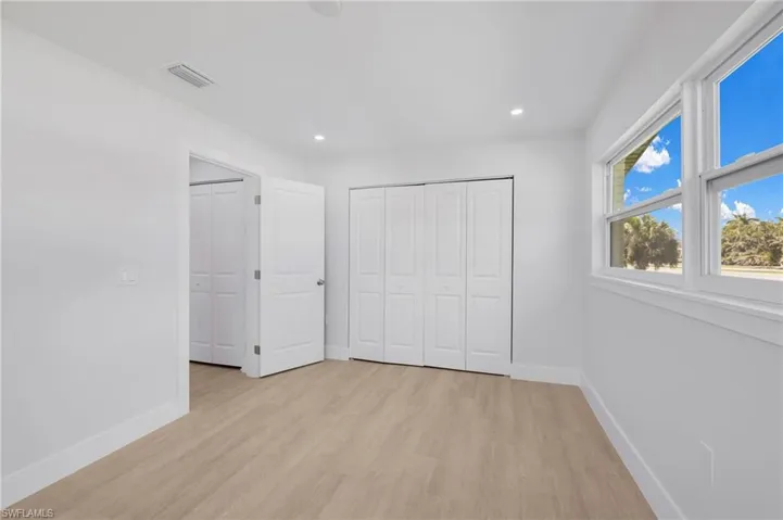 Unfurnished bedroom featuring light wood-style floors, recessed lighting, visible vents, and baseboards