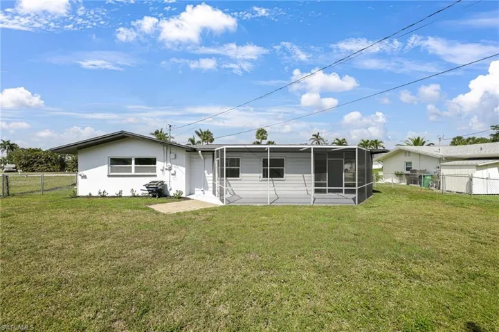 Back of property with a lawn, a fenced backyard, and a sunroom