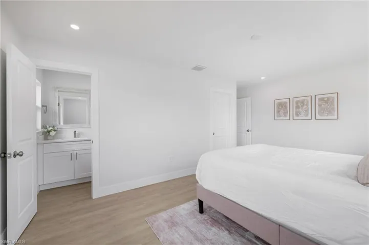 Bedroom featuring recessed lighting, a sink, visible vents, baseboards, and light wood-type flooring