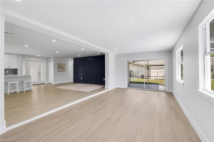 Unfurnished living room featuring light wood-style floors, recessed lighting, visible vents, and baseboards