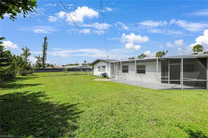 View of yard featuring a patio area, fence, and a sunroom