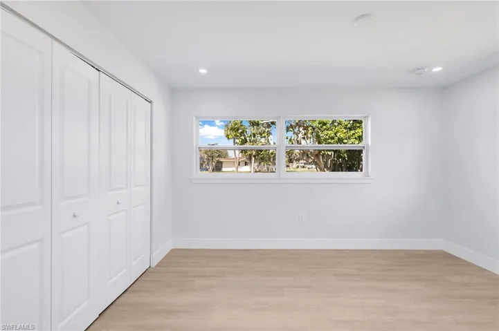 Unfurnished bedroom with light wood-type flooring, baseboards, a closet, and recessed lighting