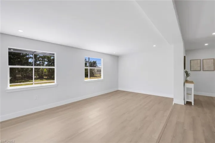 Unfurnished living room with recessed lighting, baseboards, and light wood finished floors