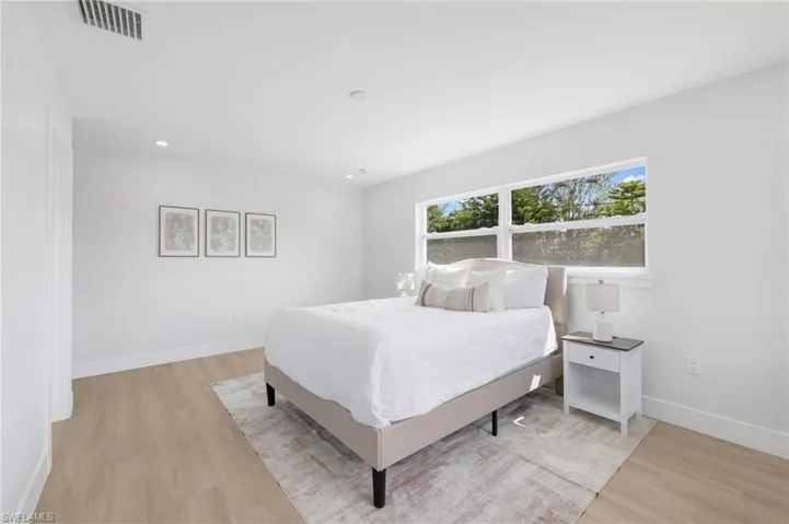 Bedroom with light wood finished floors, recessed lighting, visible vents, and baseboards