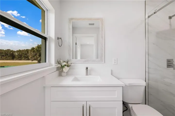 Full bathroom featuring visible vents, vanity, toilet, and walk in shower