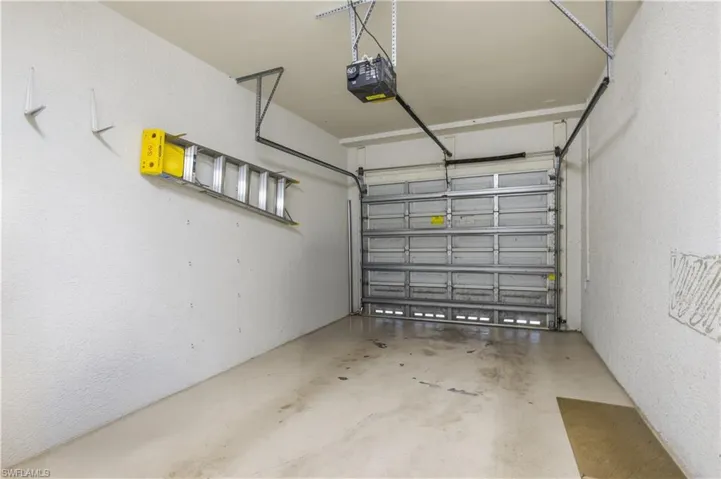 Attached garage featuring a sectional garage door and overhead opener
