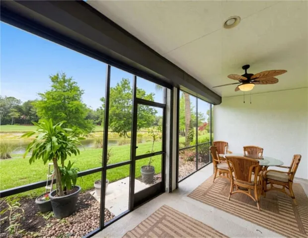 Screened patio with ceiling fan, providing exterior access and concrete flooring