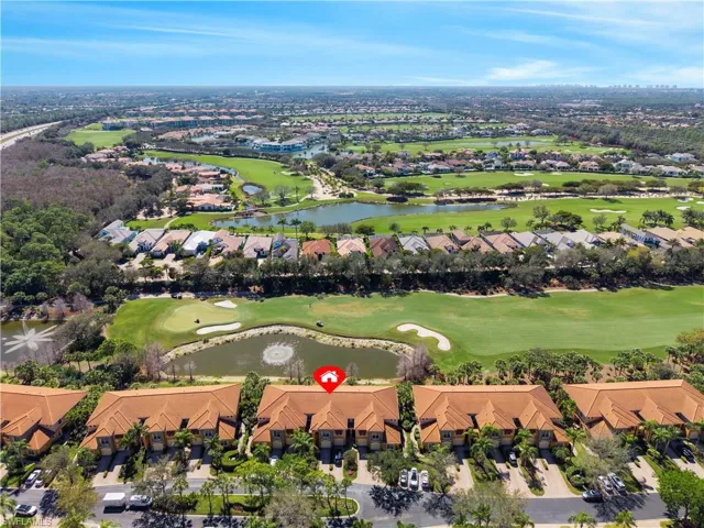 Aerial perspective of golf course property with golf course frontage, water features, and surrounding residential development
